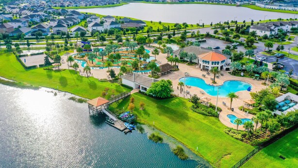 Zona residencial con un lago extenso, piscinas y un muelle.