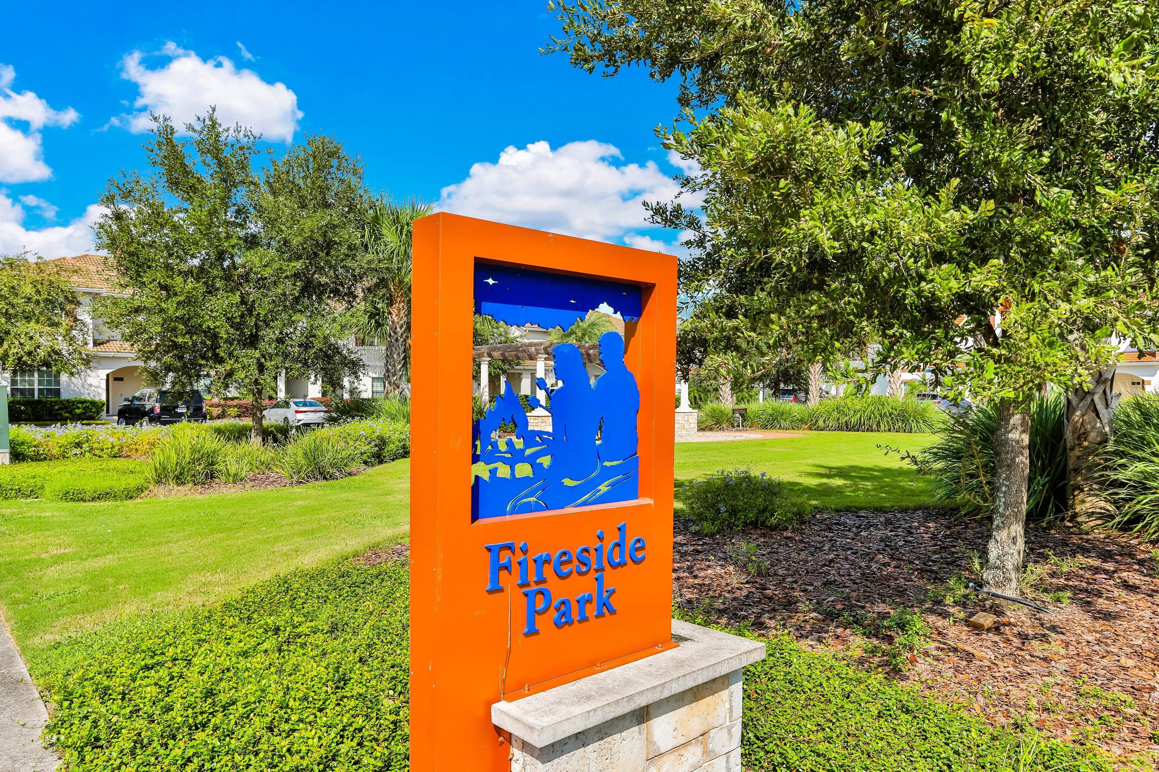 A sign for Fireside Park with a blue silhouette of a family and a starry sky.