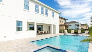 A modern two-story house with a swimming pool, outdoor seating, and a well-maintained patio. - Luxurious Home Private Pool + Spa (Kissimmee)