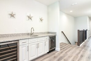 A kitchen with white cabinets, a granite countertop, and a stainless steel oven. - Luxurious Home Private Pool + Spa (Kissimmee)