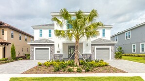 A modern two-story house with a central entrance, a garage on each side, and a well-maintained lawn. - Luxurious Home Private Pool + Spa (Kissimmee)
