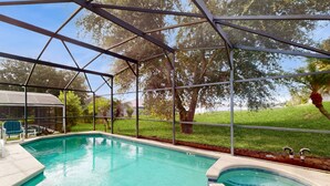 A covered outdoor swimming pool with a safety fence, a hot tub, and a patio area with chairs. - Spacious, Dog-friendly Home With Private Pool, Wifi, & Fun-filled Game Room (Davenport)