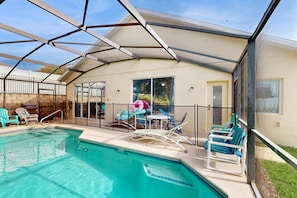 Ein Poolbereich mit Glasumrandung, Liegestühlen und einem Tisch.