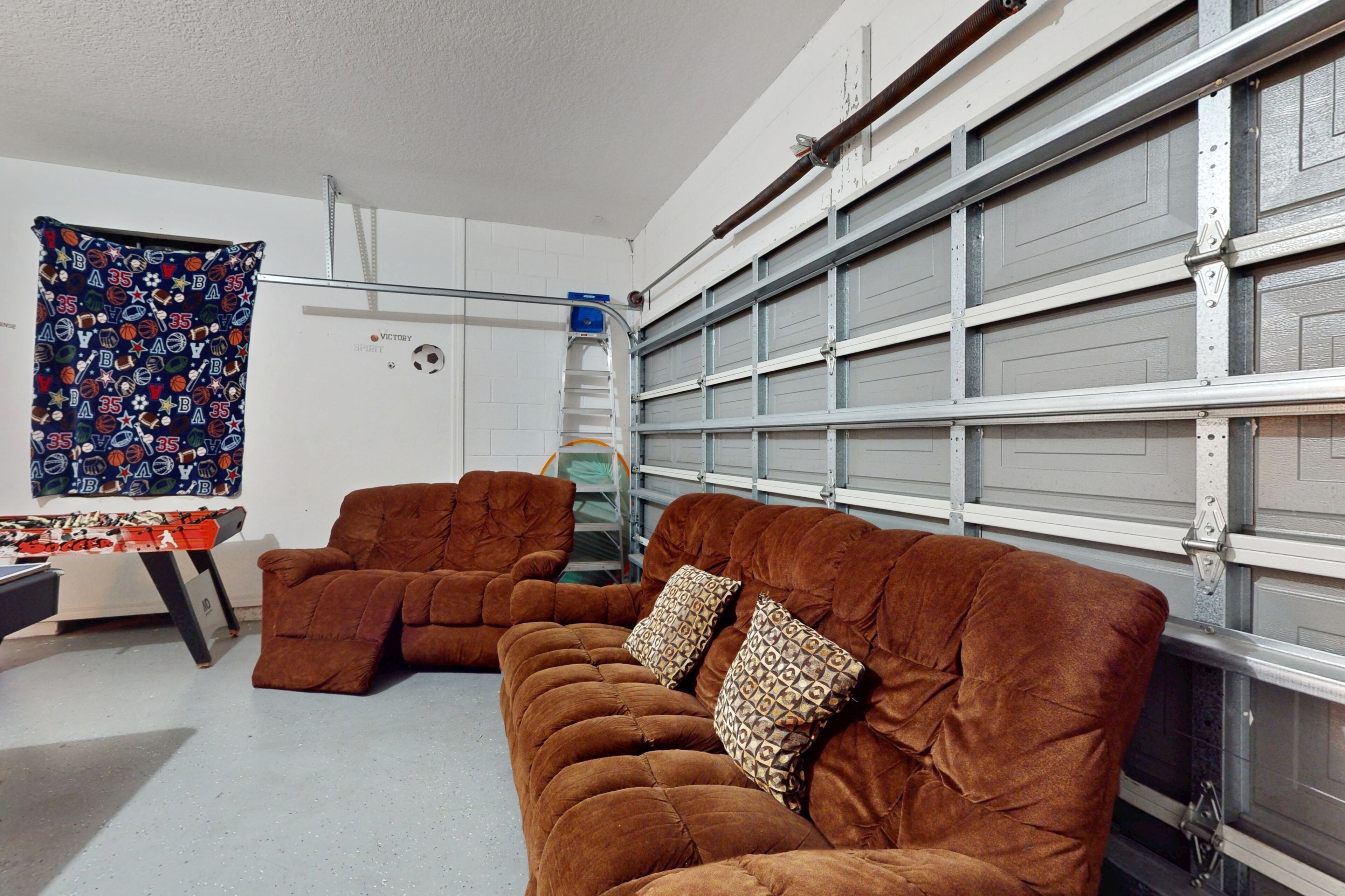 Eine Garage mit zwei braunen Sofas und einem gemusterten Vorhang.