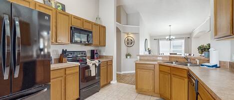 A modern kitchen with wooden cabinets, stainless steel appliances, and a central island.