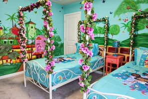 Ein Zimmer mit einem Bett, einem Nachttisch und einem Wandgemälde.