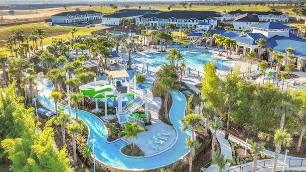 Un resort con una grande piscina, scivoli acquatici e diversi edifici per gli ospiti.
