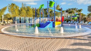 Un parco acquatico con una fontana centrale, scivoli e una piscina.