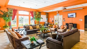 Eine geräumige Lobby mit hoher Decke, mehreren Sitzbereichen und großen Fenstern.