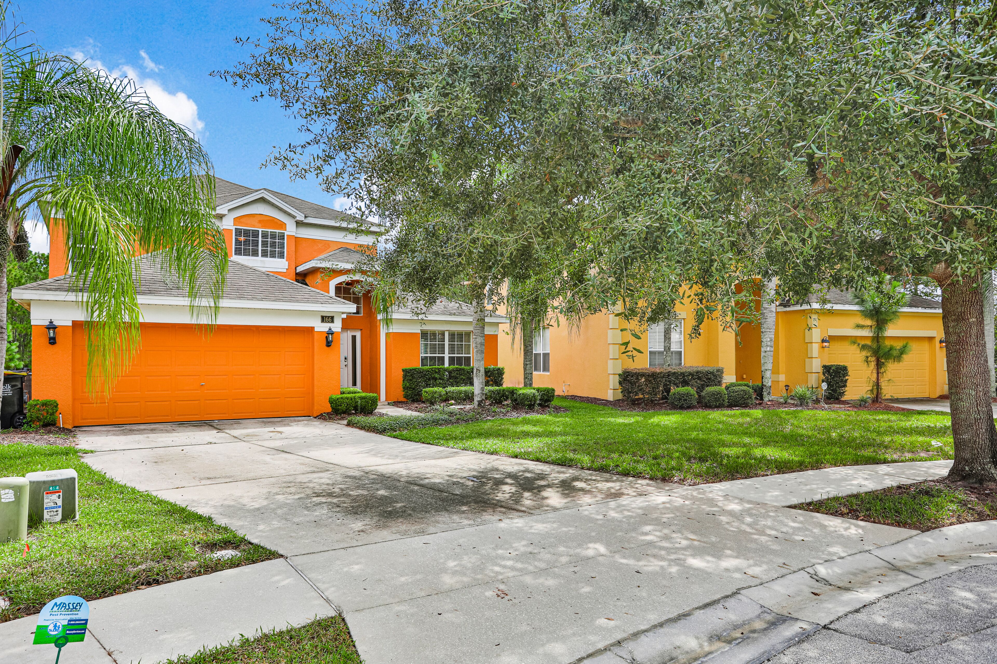 A residential area with houses, a driveway, and a lawn.