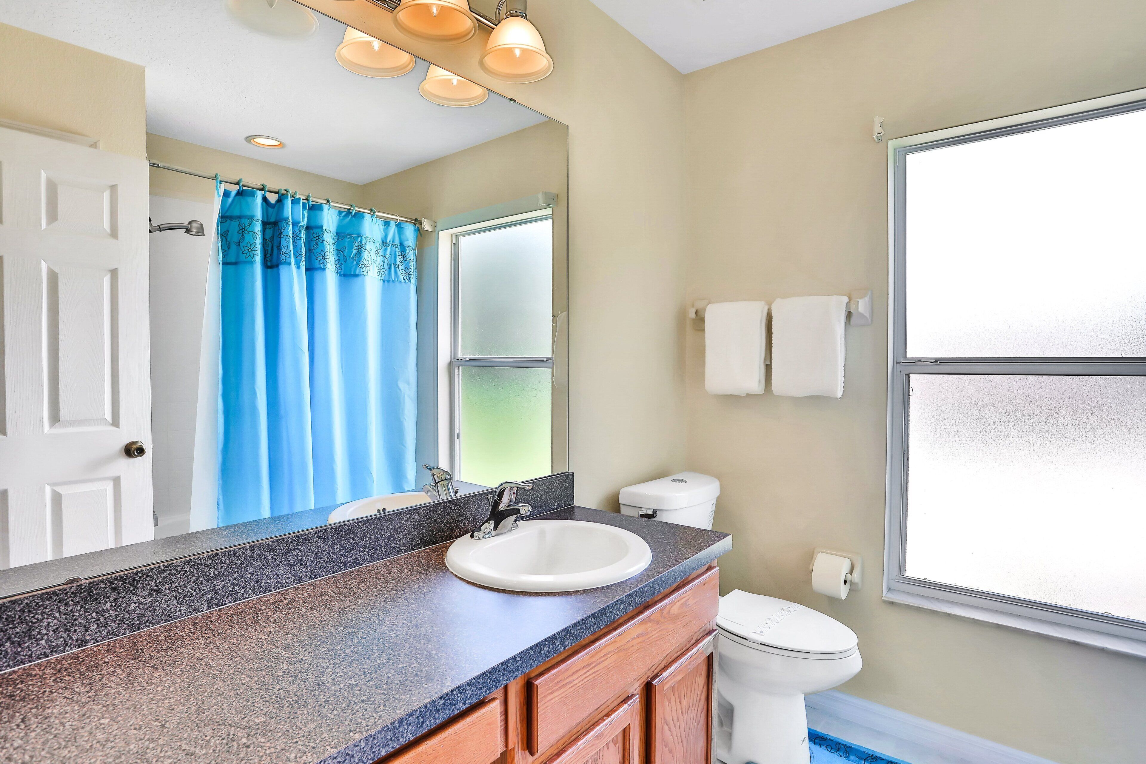 A bathroom with a sink, mirror, and toilet.