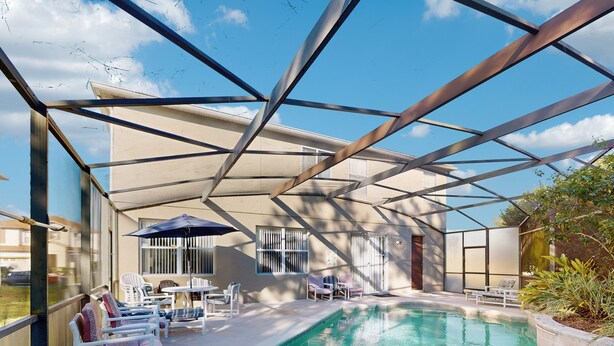 Uma piscina ao ar livre coberta, com espreguiçadeiras e guarda-sóis, cercada por uma estrutura metálica.