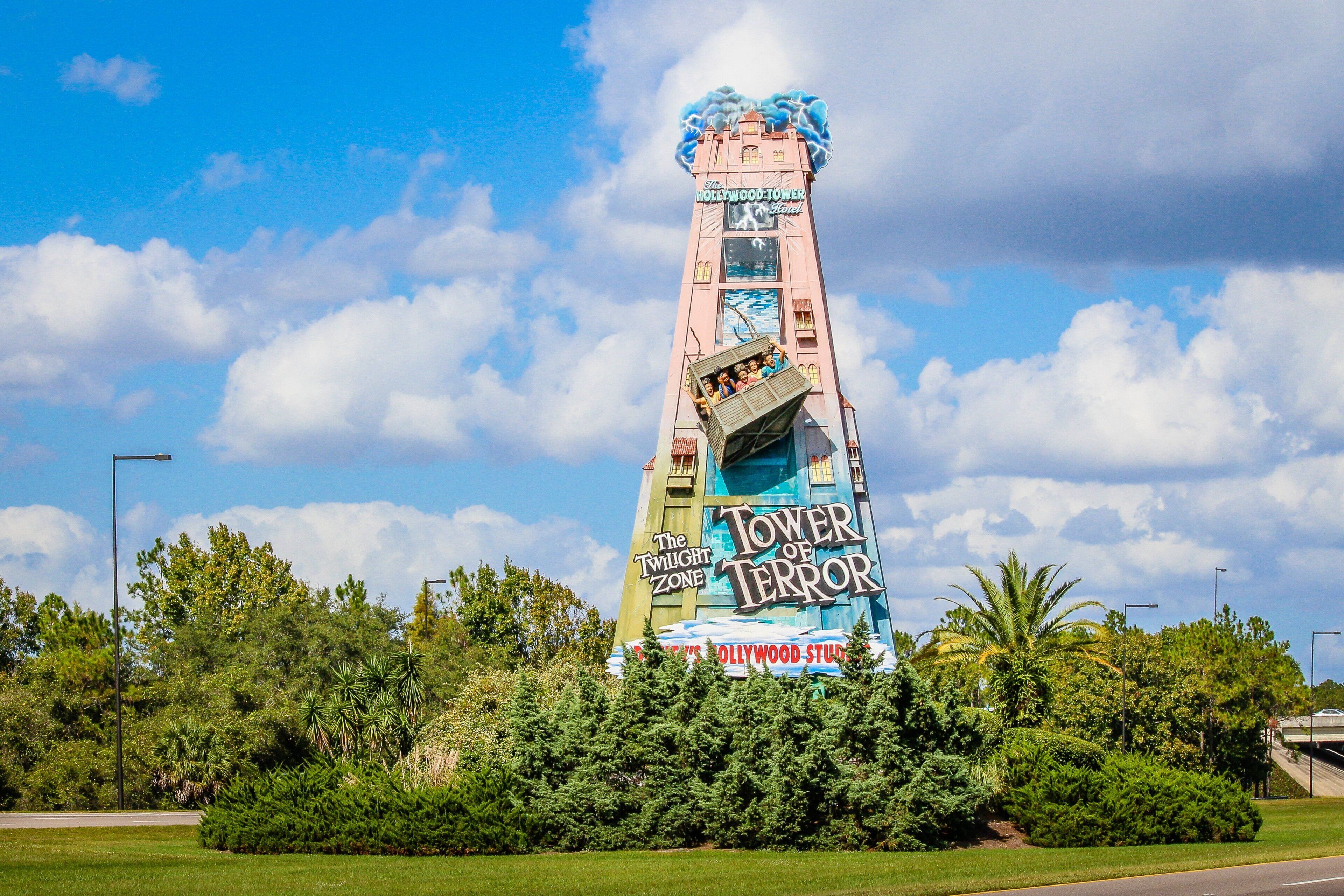 A tall tower with 'The Twilight Zone' and 'Tower of Terror' signage, surrounded by greenery.