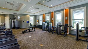 A gym with treadmills, weight machines, and dumbbells. - Solterra Escape Private Pool Café, Tennis & Water Park With Lazy River (Davenport)