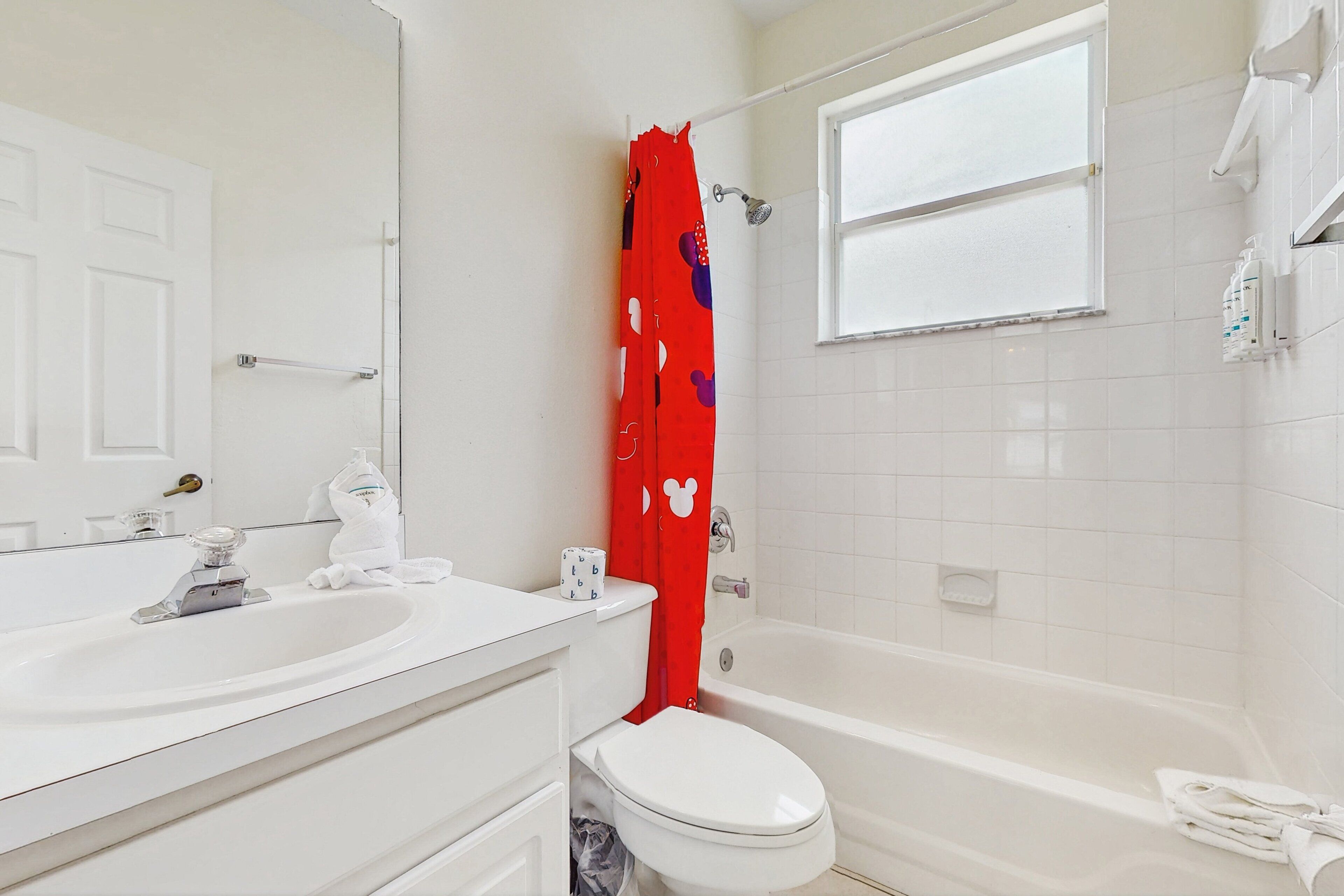 Une salle de bain avec un lavabo, des toilettes et une baignoire, le tout de couleur blanche.