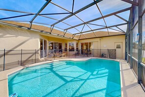 A swimming pool with a glass ceiling, chairs, and a sunshade. - Gated Community Home With Private Pool, Screened Lanai, & W/D - Near Disney/golf (Davenport)