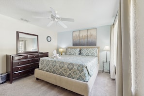 A bedroom with a bed, dresser, ceiling fan, wall clock, and artwork. - Wonderful, Two-level Home Close to Theme Parks With W/d, Central AC & Patio (Davenport)