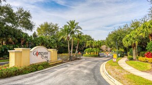 Una strada che conduce a un edificio con un cartello che riporta 'Compass Bay'.