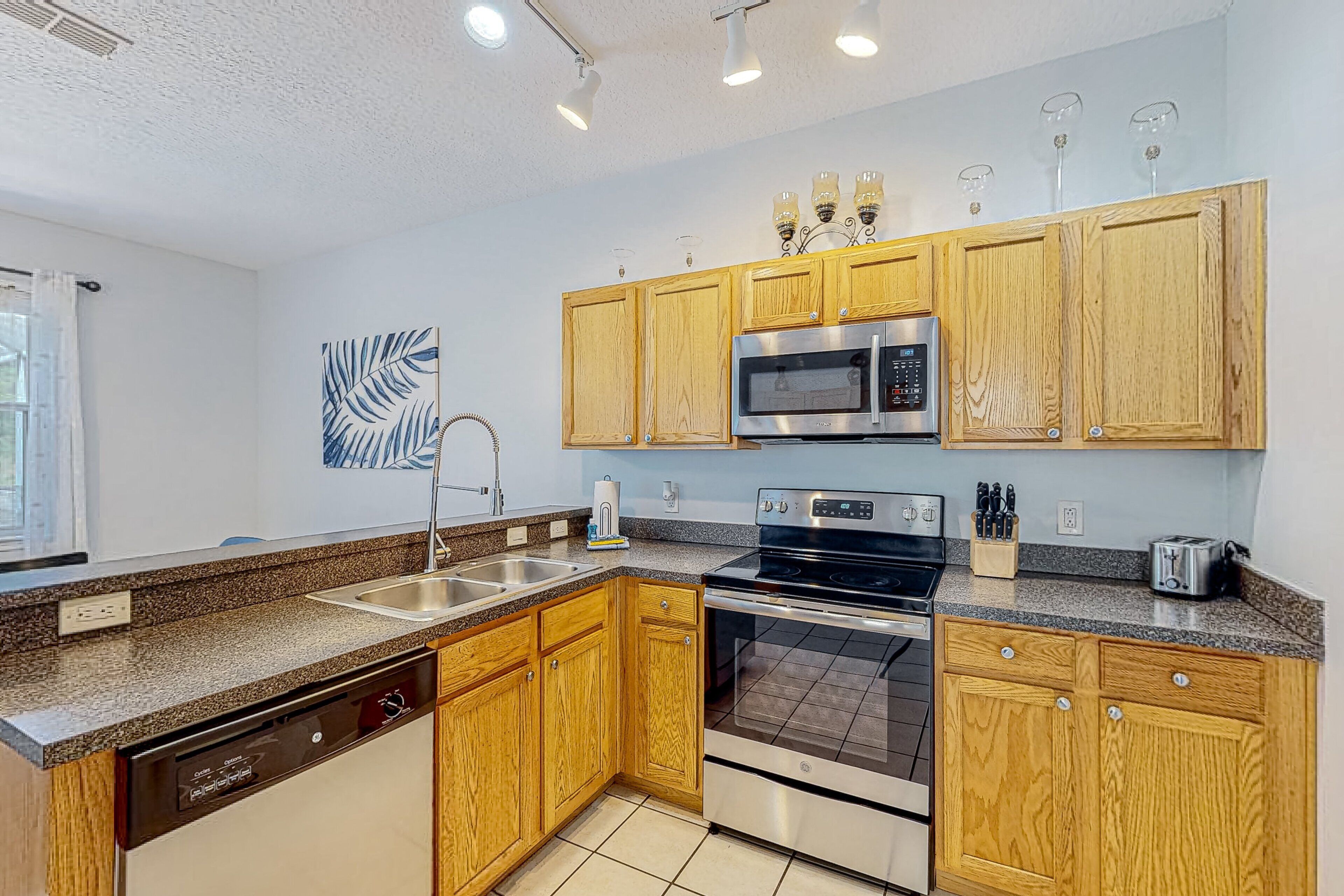 A modern kitchen with wooden cabinets, stainless steel appliances, and a dishwasher.