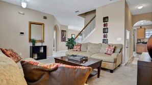 Ein Wohnzimmer mit einer Couch, einem Couchtisch und einer Treppe zu einer weiteren Ebene.
