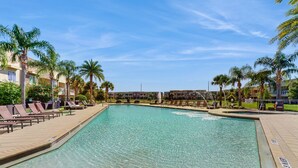 A swimming pool with lounge chairs and palm trees. - Beautiful Home With Resort Pool and Space for the Whole Family (Kissimmee)
