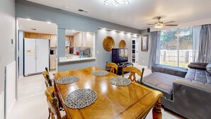 A modern living space with a dining area, kitchen, and seating area. - Comfortable Townhome Near Disney With Athletic Courts & Pool Access, Patio, & AC (Davenport)