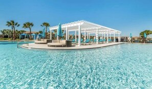 Una piscina con un pergolato bianco e sedie a sdraio.