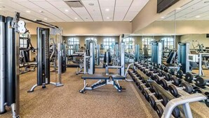 A gym with various exercise equipment, mirrors, and a bench. - Beautiful Home With Private Pool and Space for the Whole Family (Kissimmee)