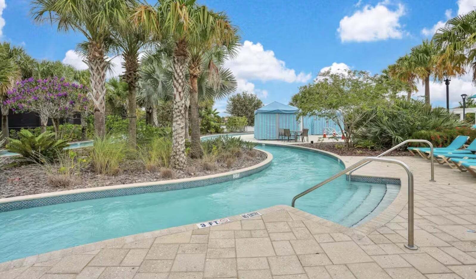 A swimming pool with a 3 FT depth marker, surrounded by palm trees and lounge chairs.