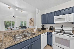 Una cocina moderna con encimeras de granito, electrodomésticos de acero inoxidable y armarios azules.