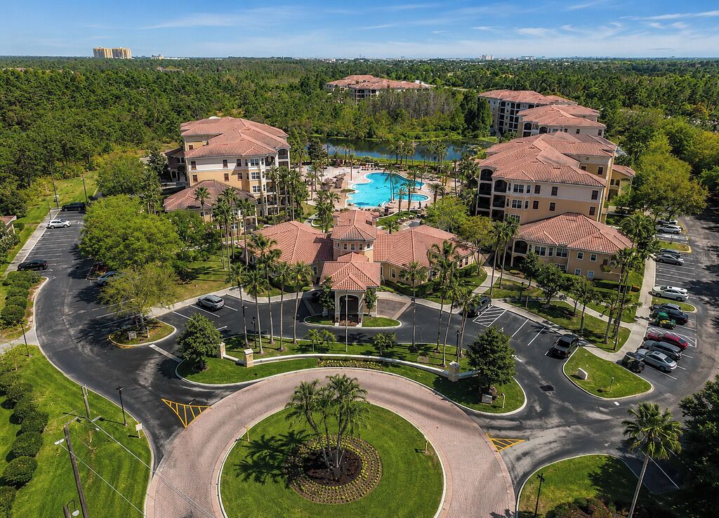 Un resort con piscina central, varias construcciones y zona de estacionamiento.