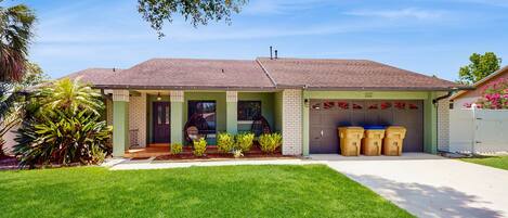 A single-story house with a garage, a well-maintained lawn, and a clear sky.