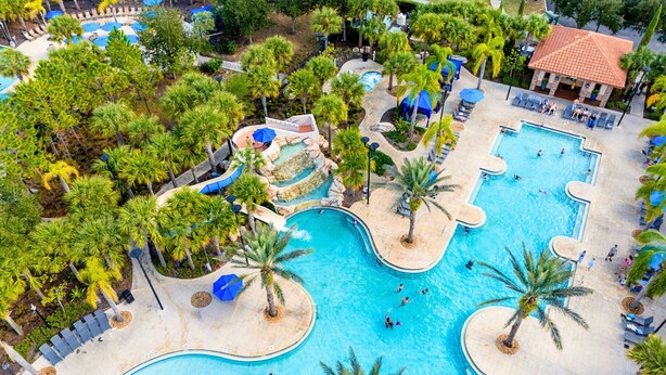 A resort with multiple swimming pools, palm trees, and a water slide. - Spacious, Lakefront Home With a Lanai, Private Pool, Spa, & Washer/dryer (Davenport)