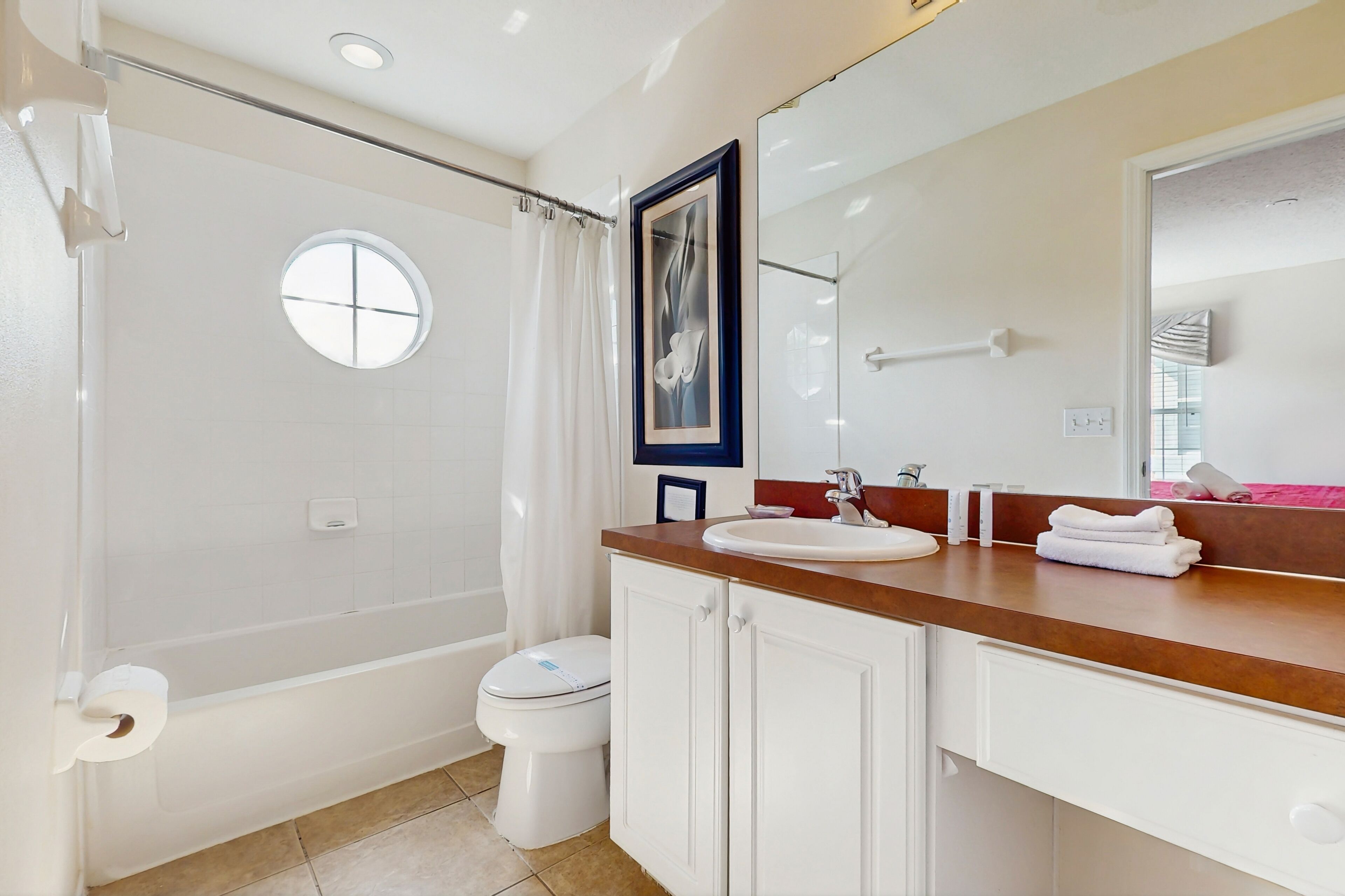 A bathroom with a bathtub, toilet, and sink.