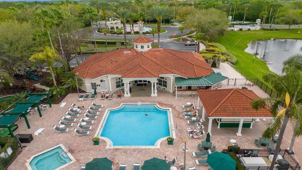 A resort with a central pool, lounge chairs, and a covered patio area.