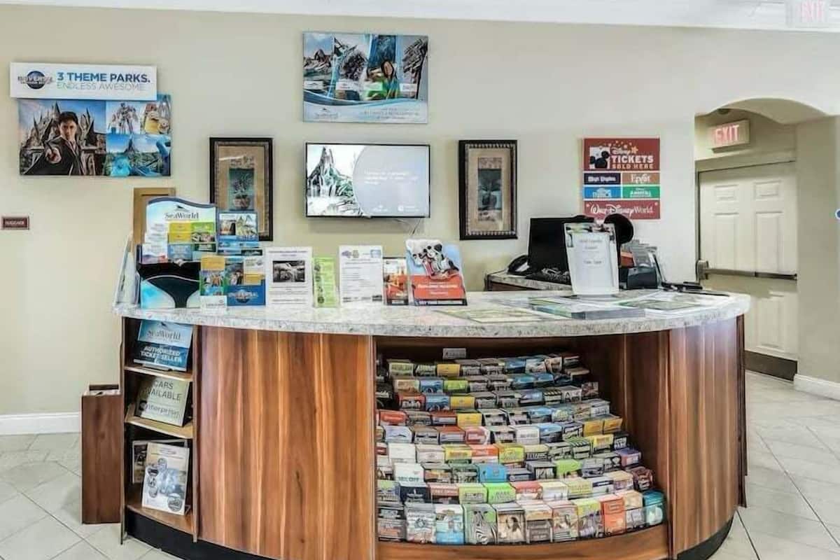 A reception desk with a counter, a computer, and a display of books and magazines.