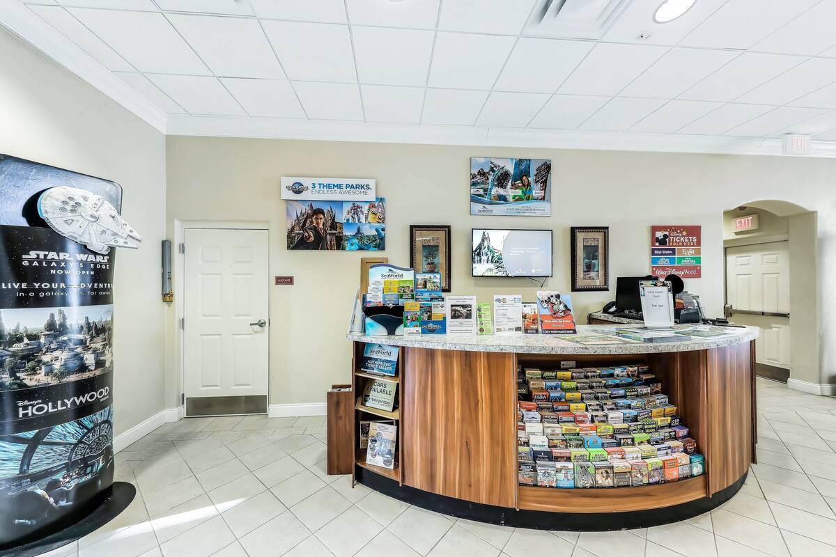 A reception desk with a counter displaying various travel brochures and a Star Wars poster.