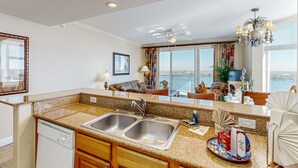 A kitchen with a double sink, a dishwasher, and a dining area with a view. - Blue Heron Beach II (Orlando)