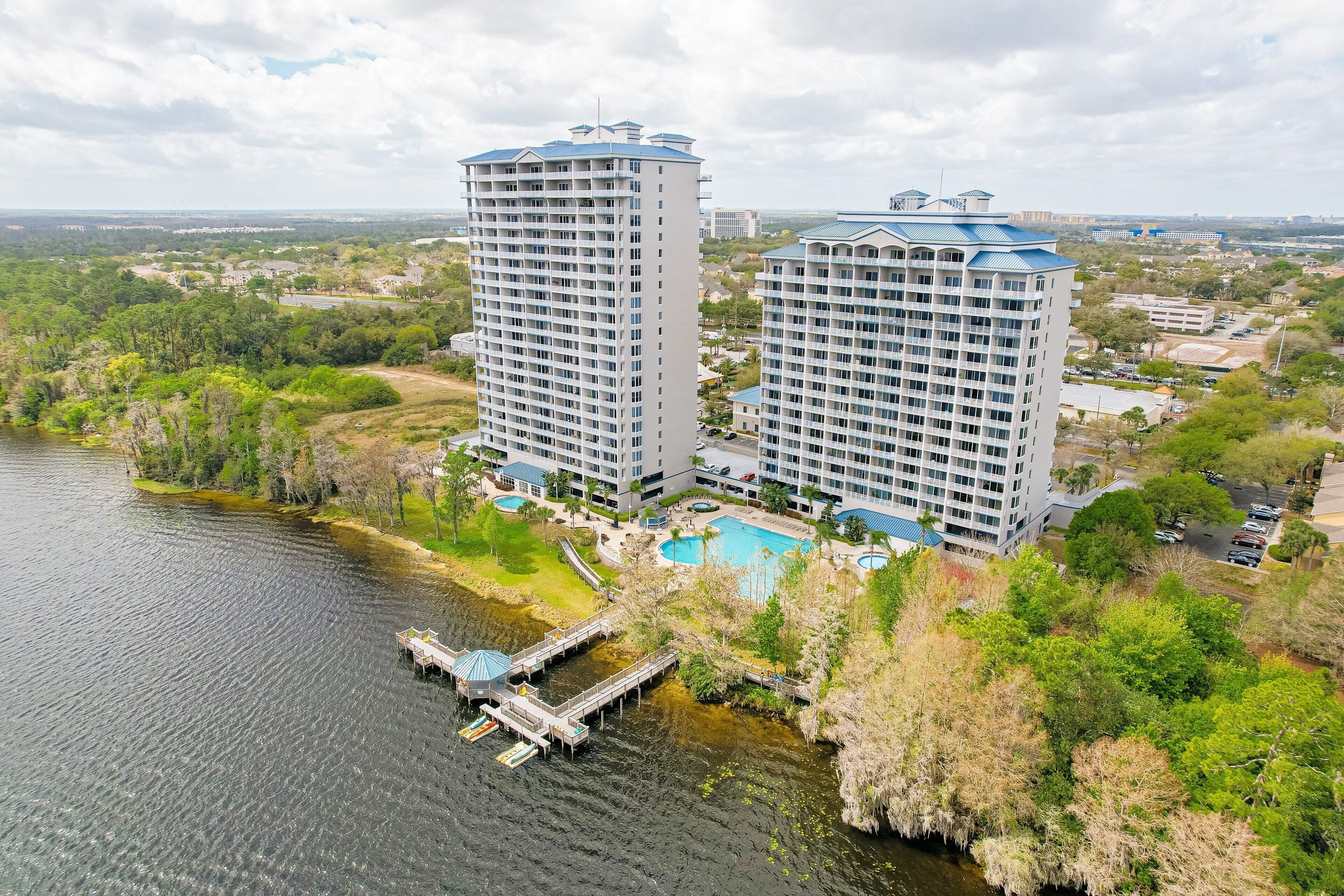 A high-rise hotel with a pool, located near a body of water.