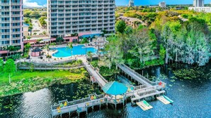 A hotel with a pool, dock, and surrounding greenery. - Blue Heron Beach II (Orlando)