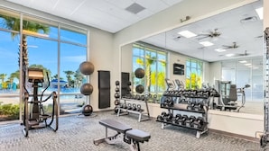 A gym with exercise equipment, a bench, and a rack of dumbbells. - Spacious Private Home w/ Private Pool, Resort Style Waterpark & Mini Golf Access (Davenport)