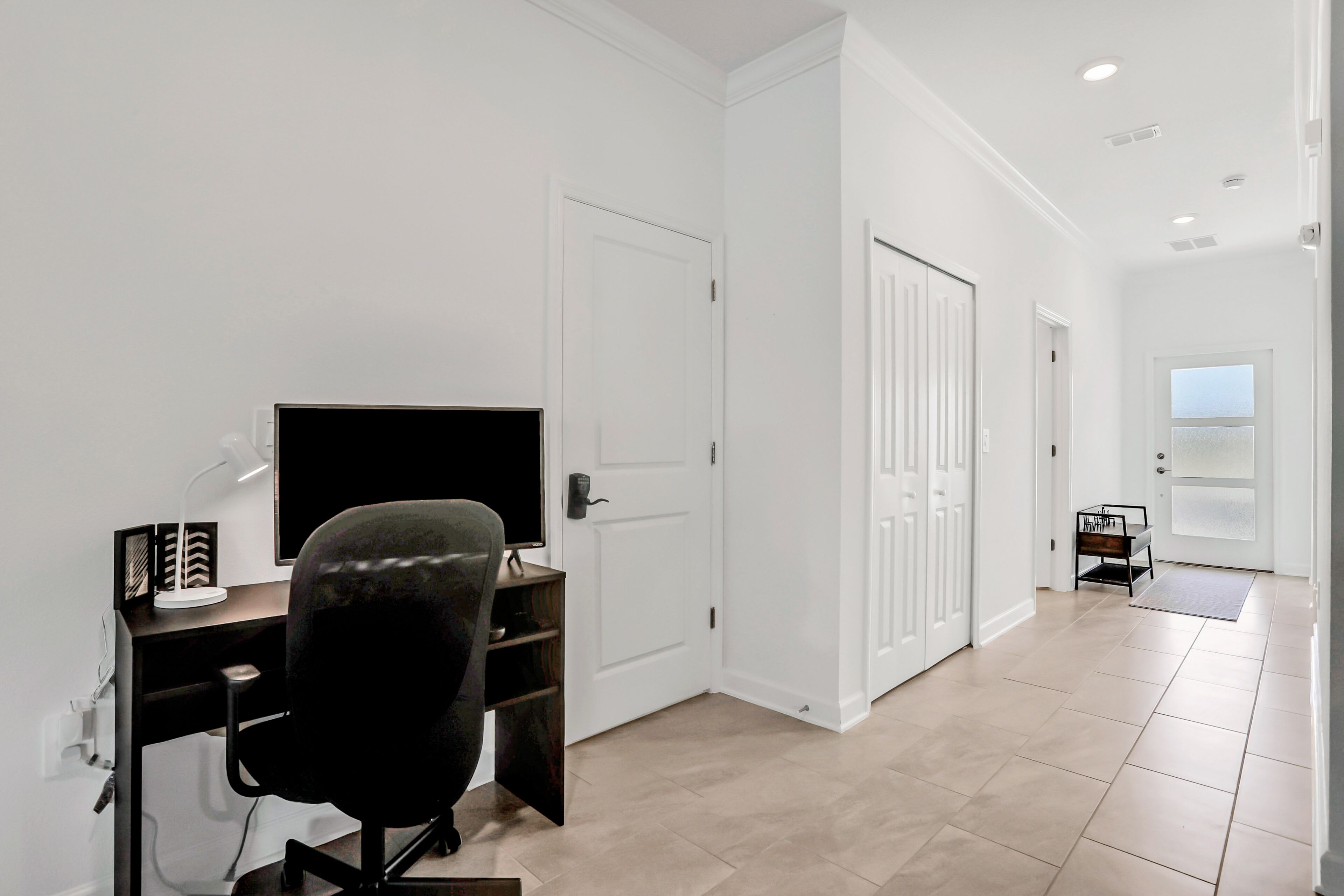Une chambre moderne équipée d’un bureau, d’une chaise et d’une grande fenêtre.