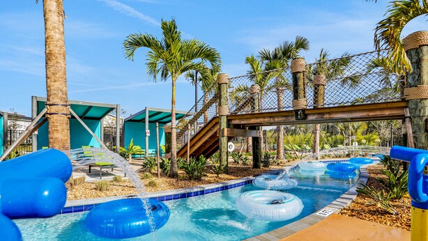 A swimming pool with inflatable rings, palm trees, and a wooden bridge. - Updated Townhome With an Enclosed Pool, Five Bedrooms, W/D - Close to Everything (Kissimmee)