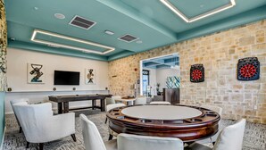 A modern room with a dartboard, a pool table, and comfortable seating. - Updated Townhome With an Enclosed Pool, Five Bedrooms, W/D - Close to Everything (Kissimmee)