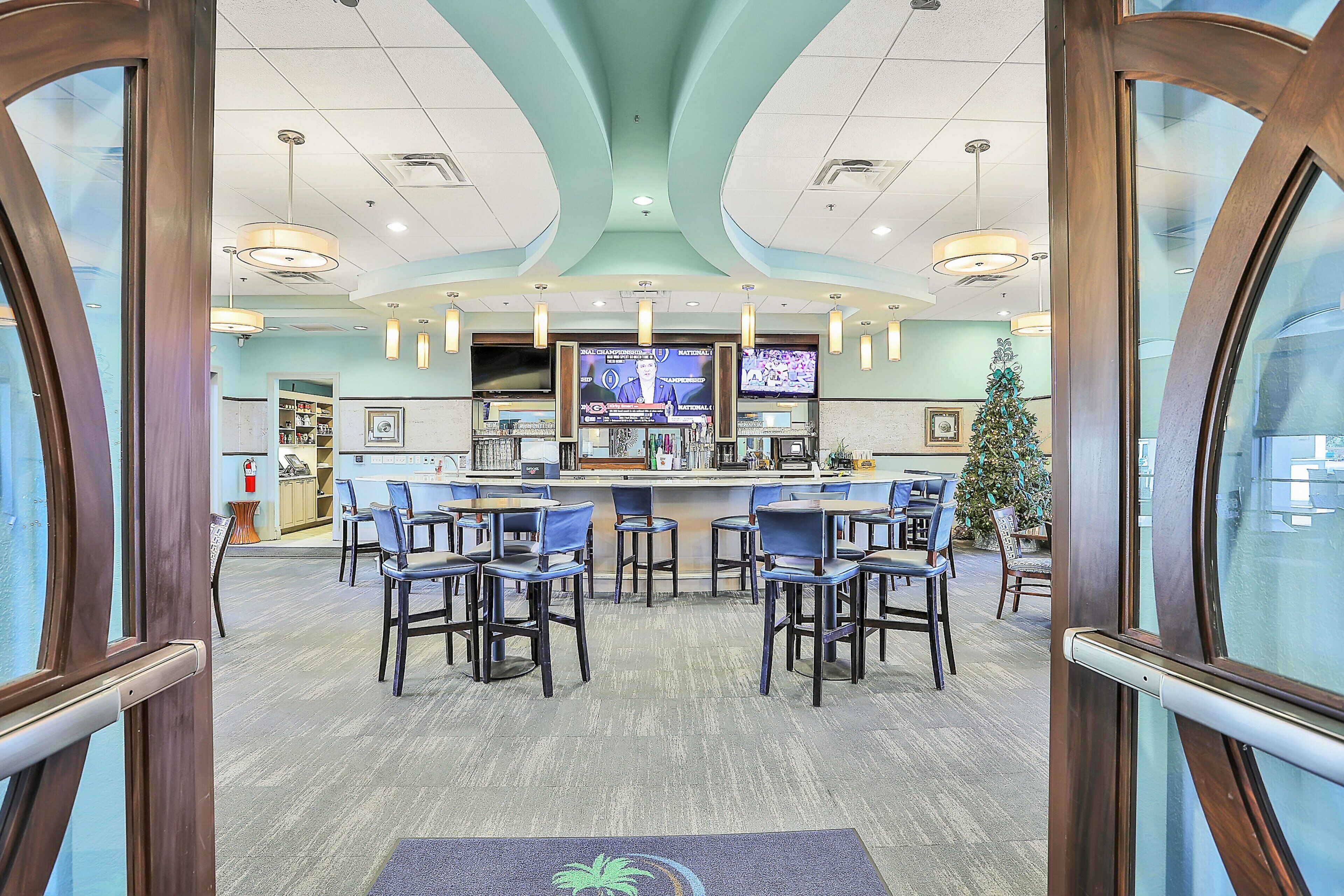 A bar area with multiple chairs and a television screen displaying news.