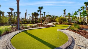 A golf course with a putting green, palm trees, and a giraffe statue. - Contemporary Townhouse w/ Private Pool and Resort Amenities, Near Attractions (Clermont)