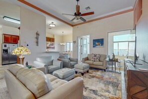 A spacious living room with a ceiling fan, a dining area, and a kitchen. - Lakefront Home With Private Dock, Garage Parking, Sunroom,w/d & Wifi (Sebring)