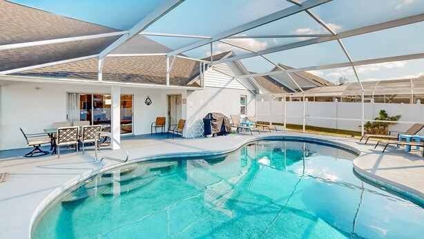 A pool area with lounge chairs and a covered seating area. - Dog-friendly Getaway With Private Pool, Tennis & AC - Near Theme Parks (Davenport)