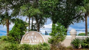 A sign for 'Loma Vista' with a circular design, surrounded by lush greenery and trees. - Dog-friendly Getaway With Private Pool, Tennis & AC - Near Theme Parks (Davenport)