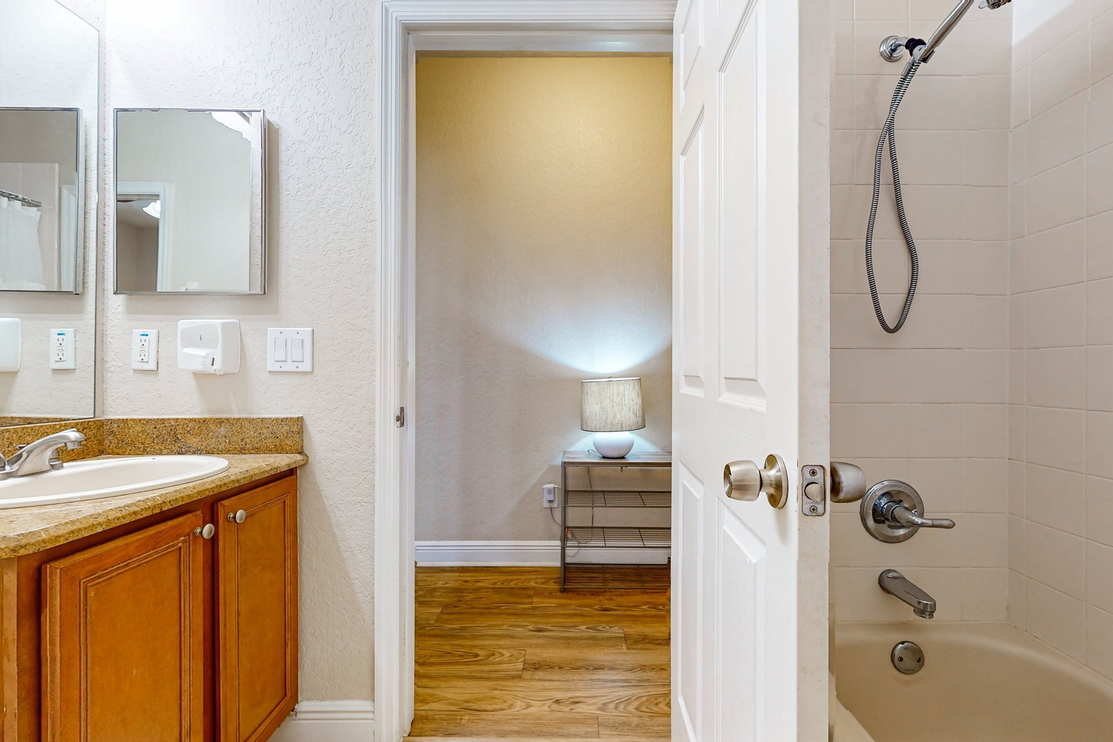 Une salle de bain équipée d’un lavabo, d’un miroir, d’une douche et d’un porte-serviettes.